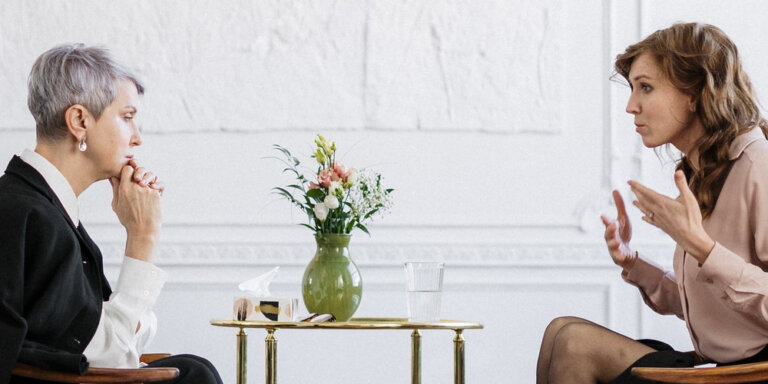 Two women in a serious discussion during consultation or mediation