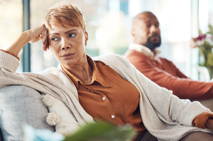 Mature couple, divorce and fighting on sofa in house, home living room or marriage counseling therapy. Stress, frustrated or depression for black woman and man in psychology counselling for cheating