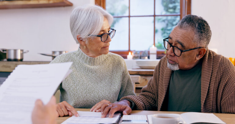 Couple, documents and reading for in retirement, planning and bills or paperwork. Senior people, marriage and communication or discussion for future, saving and finance in kitchen at home