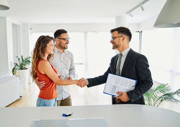 Real estate lawyer with couple shaking hands closing a deal