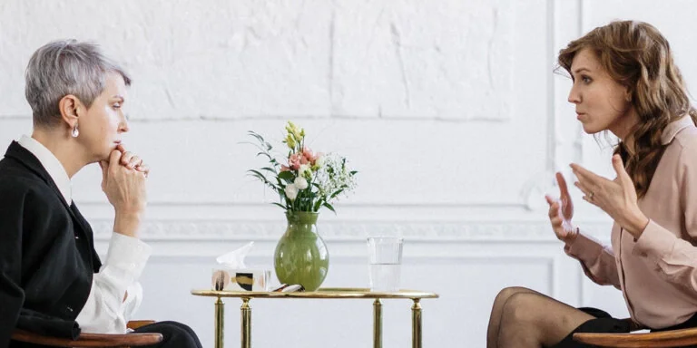 Two women in a serious discussion during consultation or mediation