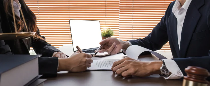 “Lawyer reviewing legal documents with client at office desk.”