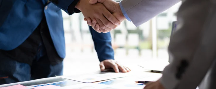 “Close-up of two people finalizing a deal with a handshake.”