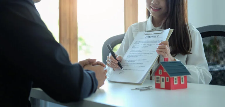Young asian man negotiate with real estate agents about renting or buying home in the office."