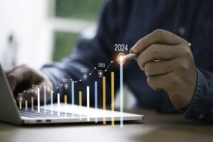 Businessman use electronic pen writing rising colorful graph from 2023 to 2024 year of business planing and stock investment growth concept.