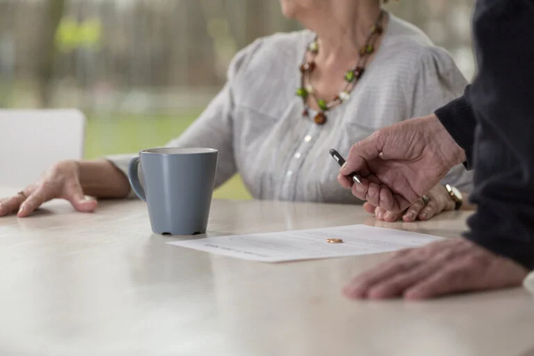 Close-up of elder man signing probate documents