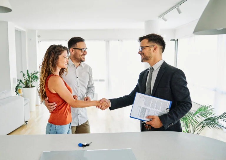 Real estate lawyer with couple shaking hands closing a deal