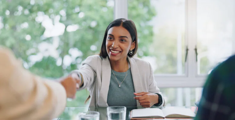 lawyer woman, handshake and interview thank you with success and agreement in office. Happy, hiring and female professional at company with motivation and shaking hands with job introduction